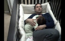 Father climbs into baby crib