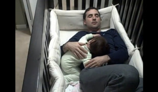 Father climbs into baby crib